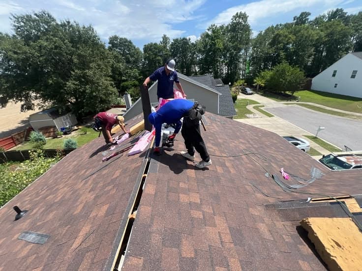Avon Exteriors crew laying shingles on a suburban roof